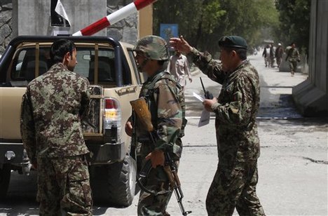 Afghan National Army soldiers secure the gate of the military hospital after Arsala Rahmani, a former Taliban official turned Afghan peace negotiator, was killed by an unknown attacker in western Kabul, Sunday, May 13, 2012.