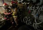 Hull Maintenance Technician 3rd Class Oscar Williams and other Sailors stand a re-flash watch after extinguishing a simulated fire in an aircraft elevator machinery room.