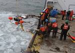 STRAITS OF MACKINAC - Crewmembers aboard the Coast Guard Cutter Hollyhock, homeported in Port Huron, Mich., use an oil-skimming device to recover peat moss, acting as a substitute for spilled oil, near Mackinac Island, Jan. 24, 2012. The crew of the Hollyhock is participating in a project led by the Coast Guard's Research and Development Center, showcasing techniques for removing spilled oil from a frozen environment. U.S. Coast Guard photo by Petty Officer 1st Class Matthew Schofield. (1505364)