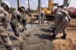 Royal Thai Armed Forces and Indonesian service members, along with U.S. Soldiers with the 643rd Engineer Company, shovel concrete over a foundation at the Ban Lumgoen school in Pak Tong Chai, Nakhon Ratchasima province, Thailand, Jan. 24, 2012, during exercise Cobra Gold 2012. The foundation is part of a multipurpose building being constructed at the school. Cobra Gold is a regularly scheduled joint/combined exercise designed to ensure regional peace and strengthen the ability of the Royal Thai