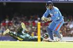 Australia's Matthew Wade (on the ground) slides home safely as India's wicket keeper MS Dhoni, right, attempts to run him out during the One Day International cricket match between Australia and India in Brisbane, Australia, Sunday, Feb. 19, 2012.