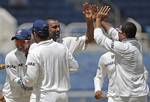 India's Praveen Kumar, third from center, is congratulated by teammates Suresh Raina, left, captain Mahendra Singh Dhoni and Murali Vijay, right, after taking the wicket of West Indies' Shivnarine Chanderpaul, who was caught by Raina for 30 runs, in the second innings during the fourth day of their first cricket Test match in Kingston, Jamaica, Thursday, June 23, 2011.