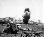 A 6th Division Marine demolition crew watches explosive charges detonate and destroy a Japanese cave, May 1945