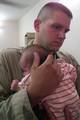 Staff Sgt. Robert Laverick of the 422nd Civil Affairs Battalion, an Army Reserve unit based in Greensboro, N.C., consoles a crying baby after the baby was given shots to prevent diseases such as measles or mumps.