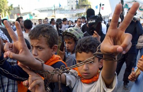 File -  Palestinians, including children making the peace sign and wearing symbolic chains. demonstrate in support of Palestinian prisoners held in Israeli jails.