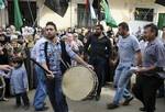 Palestinians dance and wave various flags, at the Bourj al-Barajneh Palestinian refugee camp, in Beirut, Lebanon, Tuesday Oct. 18, 2011.