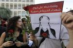 An anti-Syrian President Bashar Assad protester, holds an Arabic banner which reads: