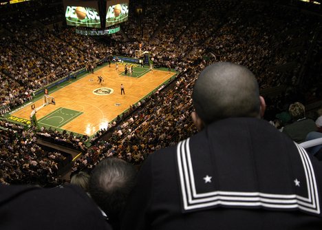 A Sailor assigned to aircraft carrier USS John F. Kennedy (CV 67) watches a basketball game between the Boston Celtics and the Minnesota Wolverines.