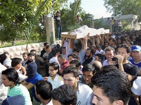 Anti-Syrian regime mourners chant slogans as they carry the body of soldier Khaled Shurbajy, who was shot by Syrian security forces in Dir el Zour last week after disobeying orders to fire on anti-Assad protesters, during his funeral procession, in the Kfar Suseh area of Damascus, Syria, on Saturday , May 26, 2012.