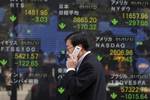 A man walks past the electronic stock board showing Japan's benchmark Nikkei 225 index, at a securities firm in Tokyo, Japan, Wednesday, Nov. 2, 2011. Asian stocks slumped for a third day Wednesday, as fears intensified that Greece might reject an austerity plan and default on its massive debts. (AP Photo/Itsuo Inouye)