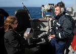 While standing watch aboard the USS Momsen (DDG 92), Boatswain's Mate Seaman Alden Fenton discusses some of the training he has received to help him spot and identify marine mammals with a journalist from CNN.