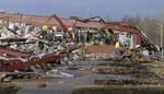 An employee of Henryville High School examines the remains of the building following severe storms Friday, March 2, 2012, in Henryville, Ind.