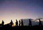 SOMALIA, Afgoye: In a photograph released by the African Union-United Nations Information Support Team 24 May, soldiers of the Somali National Army (SNA) walk at dusk under a rising crescent moon near the outskirts of the town of Afgoye, located to the west of the country's capital Mogadishu. A joint African Union Mission in Somalia (AMISOM) and SNA advance called 'Operation Free Shabelle' faced no resistance on its 3rd day as forces advanced a further 6km closer to the town of Afgoye, home to a