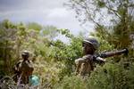 SOMALIA, Shabelle: In a photograph released by the African Union-United Nations Information Support Team, Ugandan soldiers serving with the African Union Mission in Somalia (AMISOM) walk through thicket 23 May as a battle group crosses bushland west of Deynile, in an area north-west of the Somali capital Mogadishu. AMISOM and Somali National Army (SNA) forces continued for a second day to push out to the west of Mogadishu in a major offensive called 'Operation Free Shabelle' to liberate Afgoye T