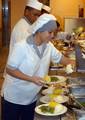 Culinary Specialist Seaman Ashley Moody, from Tulsa, Okla., scoops mashed potatoes on a plate for a customer during Thanksgiving dinner.