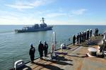 Sailors man the rails on the foc'sle of the amphibious transport dock ship USS Ponce (LPD 15) before rendering honors as Ponce overtakes the guided-missile destroyer USS Gravely (DDG 107) in the mouth of Hampton Roads.