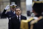 French President Nicolas Sarkozy, listens to the national anthem as he attends the traditional autumn military review at the Hotel des Invalides in Paris, Monday, Nov. 28, 2011.