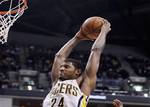 Indiana Pacers guard Paul George (24) goes up for a dunk over Miami Heat guard Dwyane Wade, front and forward LeBron James in the second half of an NBA basketball game in Indianapolis, Tuesday, Feb. 14, 2012. The Heat defeated the Pacers 105-90. (AP Photo/Michael Conroy)