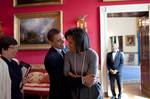 United States President Barack Obama hugs First Lady Michelle Obama in the Red Room of the White House while Senior Advisor Valerie Jarrett (left) smiles prior to the National Newspaper Publishers Association (NNPA) reception on 20 March 2009.