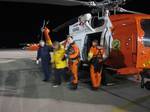 ELIZABETH CITY, N.C. - A Coast Guard MH-60 Jayhawk helicopter rescue crew escorts a 57-year-old man to waiting emergency medical service personnel at Coast Guard Air Station Elizabeth City, Jan. 15, 2011. The Coast Guard medevaced the man from his 28-foot sailing vessel, The Answer, which was sinking 50 miles east of Cape Hatteras, N.C. U.S. Coast Guard photo. (1498665) ( Coast Guard Medevac )