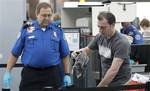 This April 30, 2012, photo shows a traveler passing through a security check point at Portland International Airport, in Portland, Ore. Airport security procedures, with their intrusive pat downs and body scans, don’t need to be toughened despite the discovery of a new al-Qaida airline bomb plot