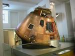 Command Module at London Science Museum (May 2009). The shield-shaped emblem for the flight shows a large, three-dimensional Roman numeral X sitting on the moon's surface, in Stafford's words, 