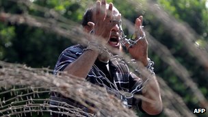 An Egyptian protester raises his clinched hands with chains as he shouts slogans during a protest against presidential candidate Ahmed Shafiq outside the Supreme Constitutional Court in Cairo on June 14, 2012 