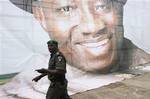 Nigeria Police Officer, walks past a Campaign of President Goodluck Jonathan, during the rulings party political Campaign, at the Tafawa Balewa Square in Lagos, Nigeria, Monday, March. 1, 2011. While many expect President Goodluck Jonathan to win Nigeria's April election, a visit to an opposition stronghold shows the leader holds a shaky grasp in some states.