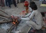 A old Indian Sadhu - Hindu holy man - blesses a pilgrim at a temporary camp in Kolkata, 08 January 2008. Thousands of Hindu pilgrims have started to converge for the Gangasagar Mela which will culminate on 14 January, on the occasion of Makar Sankranti, a holy day of the Hindu calendar, during which a dip in the ocean at the confluence of the River Ganges and the Bay of Bengal, some 150 kms south of Kolkata, is considered to be of great religious significance in Eastern India