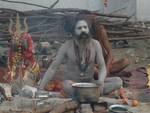 An Indian Sadhu - Hindu holy man - warms himself at a fire at a temporary camp in Kolkata, 09 January 2008. Thousands of Hindu pilgrims have started to converge for the Gangasagar Mela which will culminate on 14 January, on the occasion of Makar Sankranti, a holy day of the Hindu calendar, during which a dip in the ocean at the confluence of the River Ganges and the Bay of Bengal, some 150 kms south of Kolkata, is considered to be of great religious significance in Eastern India