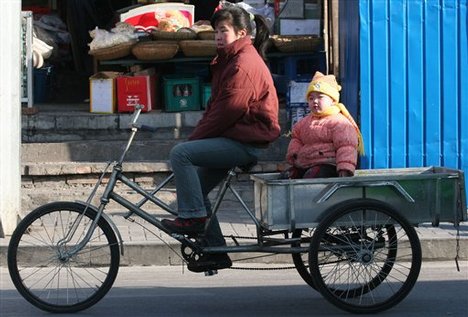  A Chinese mother and her daughter wait at a stop light in Beijing Saturday, Jan. 7, 2006. The minister of the State Commission of Population and Family Planning said China would maintain its one child policy in the coming years in order to stabilize a st