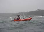 RYE, N.H. Coast Guard crewmen from Station Portsmouth Harbor work to rescue one of three men from 57-degree water about a mile off the coast of Rye, N.H., Friday, June 24, 2011. The men were knocked in the water after a wave came over the stern of their 18-foot boat and capsized it when they were recreational lobstering. Photo courtesy of the New Hampshire Fish and Game. (1296072) ( U.S. Coast Guard rescues 3 from cold water after boat capsizes )