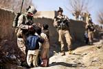 U.S. Marine Lance Cpl. Galen Murphy-Fahlgren, a 22-year-old anti-tank missileman with Combined Anti-Armor Team 2, Weapons Company, 3rd Battalion, 3rd Marine Regiment, and a native of Canton, Mich., hands candy to a group of Afghan children during a partnered security patrol with Afghan Border Police here, Jan. 30. In southern Garmsir district, an area with a history of tribal conflict, the growing ABP force has deepened its roots and established governance through the mentorship of the 3/3 Weapo