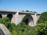 The Veterans Memorial Bridge over the Genesee River. The route heads northeast through the town of Ridgway to the hamlet of the same name, where NY 104 meets NY 63.