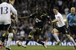 Bolton Wanderers' Fabrice Muamba, center, controls the ball beside Tottenham Hotspur's Scott Parker, right, during the English FA Cup quarterfinal soccer match at White Hart Lane stadium in London, Saturday, March 17, 2012. Bolton midfielder Fabrice Muamba has been carried off the field at Tottenham after medics appeared to be trying to resuscitate him during an FA Cup quarterfinal that was abandoned. Muamba went to the ground in the 41st minute with no players around him and the game was immedi