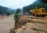 In this Monday, June 14, 2010 photo released by China's Xinhua News Agency, an excavator works at the site of an accident where a rain-triggered landslide engulfed two vehicles in Nanping, east China's Fujian Province.