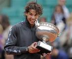 Rafael Nadal of Spain bites the trophy after winning the mens final match against Novak Djokovic of Serbia at the French Open tennis tournament in Roland Garros stadium in Paris, Monday June 11, 2012. Rain suspended the final making it the first French Open not to end on Sunday since 1973. Nadal clinched his seventh title in four sets 6-4, 6-3, 2-6, 7-5, passing Sweden's Bjorn Borg as the all-time record-holder for French Open titles.