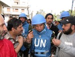 Ahmed Himmiche (centre), head of the UN Military Observers (UNMO) dispatched to Syria, is approached by citizens of Homs as he and his team patrol the city, 21 April, 2012.