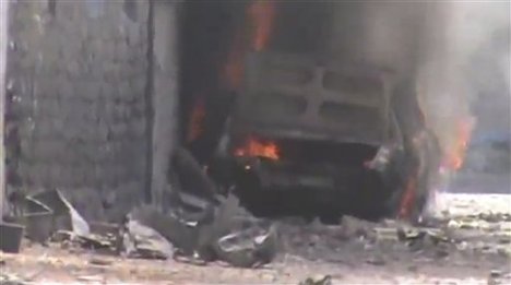 This image made from amateur video released by Shaam News Network and accessed Thursday, June 14, 2012, purports to show a burning car after shelling in Joret el-Shayah, Homs, Syria.