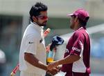 India's Virat Kohli, left, is congratulated by West Indies' Ramnaresh Sarwan after India won the first cricket Test match by 63 runs on the fourth day in Kingston, Jamaica, Thursday June 23, 2011.