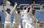 India's Murali Vijay, right, bowler Harbhajan Singh, and wicket keeper Mahendra Singh Dhoni, left, appeals unsuccessfully for the catch behind of West Indies' captain Darren Sammy, second from right, in the second innings during the fourth day of their first cricket Test match in Kingston, Jamaica, Thursday, June 23, 2011.