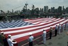 Service members unfurl an American Flag on the flight deck of the Intrepid Sea, Air & Space Museum during a Fleet Week New York 2011 Memorial Day ceremony.