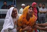 Kashmiri Muslim relatives of ruling party National Conference Block President Abdul Rehman Ganaie mourn during his funeral in Srinagar on June 15,2012. Suspected Muslim rebels gunned down Ganaie in the latest string of alleged political killings in Kashmir. Ganaie was shot at close range by suspected rebels as he was leaving his home to offer Friday prayers at a local mosque,police said.