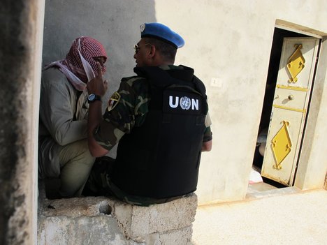 An observer with the UN Supervision in Syria (UNSMIS) interviews a local man while conducting a fact-finding mission in the Syrian village of Mazraat al-Qubeir, where a massacre of civilians reportedly took place on Wednesday, 8 June, 2012.