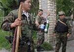 A Kyrgyz special forces officer holds sticks and Molotov cocktails seized during a search operation in the Dustuk neighborhood in the southern Kyrgyz city of Osh, Wednesday, June 16, 2010. Kyrgyzstan's weak and undersupplied military attempted Wednesday to regain control of the city of Osh, a major transit point for Afghan heroin and the epicenter of brutal rampages that have driven much of the ethnic Uzbek population from Kyrgyzstan's poor, rural south. (AP Photo/Sergei Grits)