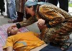 Uzbek Zulfia Sabirova, right, comforts her son Shokruh, 18, after Shokruh was allegedly beaten by Kyrgyz soldiers, who reportedly found some Molotov cocktails at local school during the search operation in Uzbek neighborhood Dustuk in the southern Kyrgyz city of Osh, Wednesday, June 16, 2010. Heavy arms fire rang out over the Kyrgyz city of Osh before dawn Wednesday as authorities struggled to bring order to the country's south, which has been thrust into chaos by days of deadly ethnic riots. Th