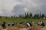 Uzbek men pray during the funeral ceremony of the remains of victims killed during ethnic rioting between Kyrgyz and ethnic Uzbeks, in the southern Kyrgyz city of Osh,Wednesday, June 16, 2010. The official death count from the past week of violence rose to 189 on Wednesday, with 1,910 wounded, the Health Ministry said. Kyrgyzstan is observing 3 days of mourning for the victims of the recent mass-scale riots in the republic's southern regions. (AP Photo/Sergei Grits)