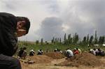 Uzbek men pray during a funeral ceremony for the remains of victims killed during ethnic rioting between Kyrgyz and ethnic Uzbeks, in the southern Kyrgyz city of Osh, Wednesday, June 16, 2010. The official death count from the past week of violence rose to 189 on Wednesday, with 1,910 wounded, the Health Ministry said. Kyrgyzstan is observing 3 days of mourning for the victims of the recent mass-scale riots in the republic's southern regions. (AP Photo/Sergei Grits)