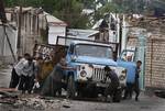 Uzbek men push a truck as they build a barricade in the Uzbek district in the southern Kyrgyz city of Osh, Thursday, June 17, 2010. Some 400,000 people have been displaced by ethnic violence in southern Kyrgyzstan, the United Nations announced Thursday, dramatically increasing the official estimate of a refugee crisis that has left throngs of desperate, fearful people without enough food and water in grim camps along the Uzbek border. (AP Photo/Sergei Grits)