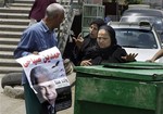 Egyptian women talk to a man distributing posters of Egyptian presidential candidate Hamdeen Sabahi, the leader of the opposition Dignity Party, with Arabic that reads, "Hamdeen Sabahi, one of us," in Cairo, Egypt, Monday, May 21, 2012.